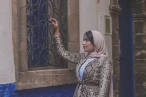 woman in black and white floral hijab sitting on blue floor