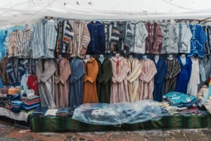 Colorful djellabas displayed at an outdoor market stall.