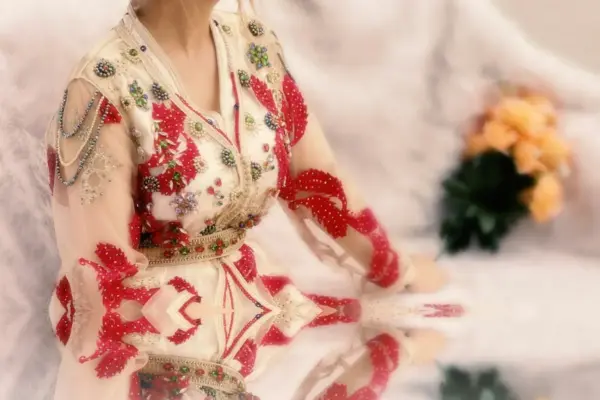 a woman in a red and white dress sitting down