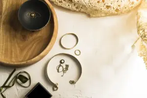Gold jewellery on a mango wood tray top view
