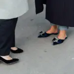 two people standing next to each other wearing blue shoes