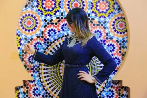 woman in black long sleeve dress standing near wall with graffiti