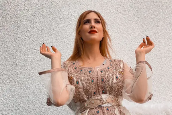 a woman in a dress holding a cigarette